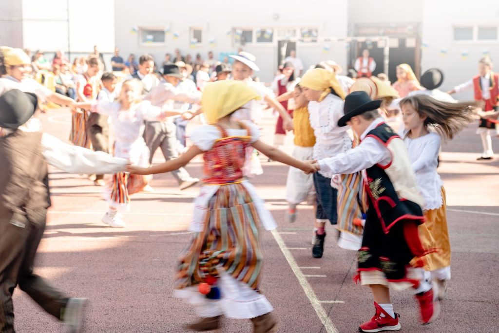 Crafting Captivating Headlines: Your awesome post title goes here Children in traditional costumes dancing outdoors at a cultural festival in La Orotava, Spain.